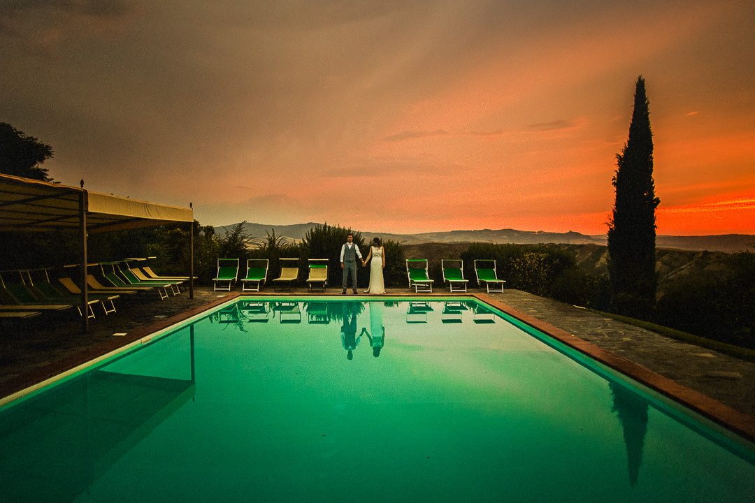 Tuscany wedding photograph of couple stood poolside
