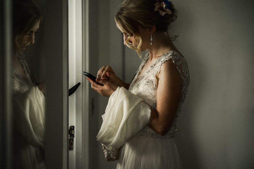bride in wedding dress awaits confirmation of taxi to take her to wedding ceremony