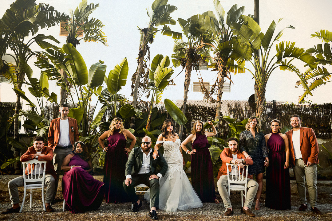 a stylish and alternative wedding group shot with palm trees in ibiza