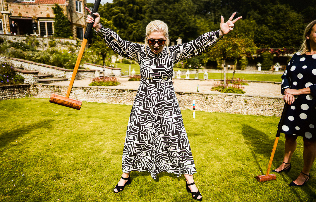 wedding guest celebrates in bold print dress during lawn games