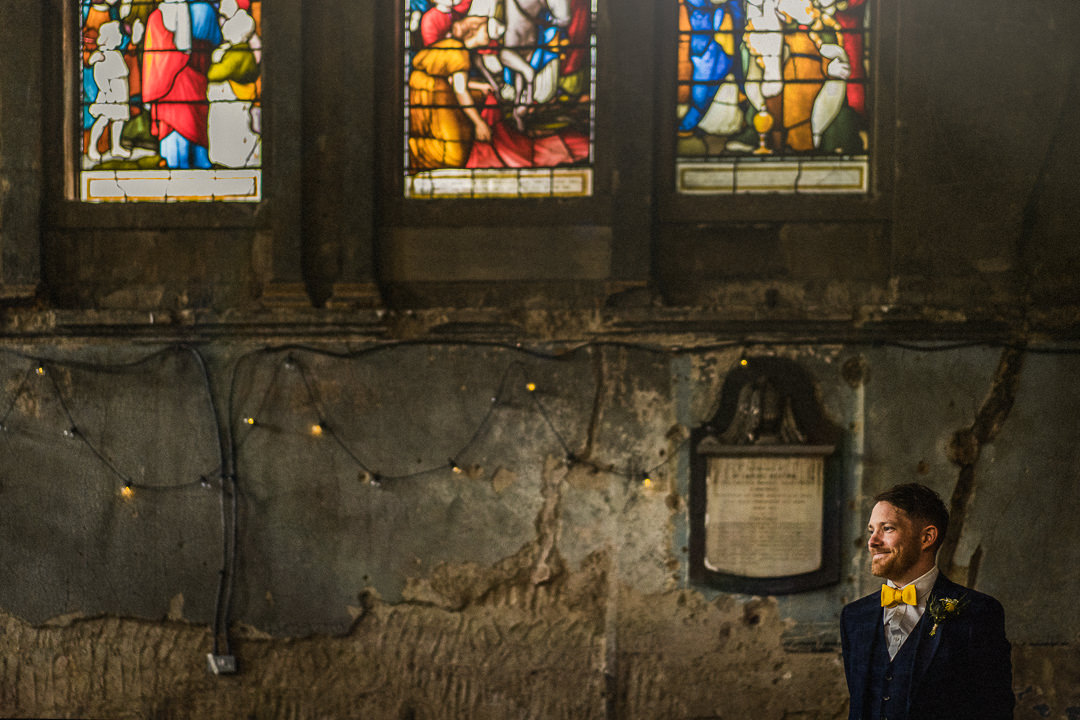 a groom reacts to a bride entering the asylum chapel in London ahead of their wedding ceremony