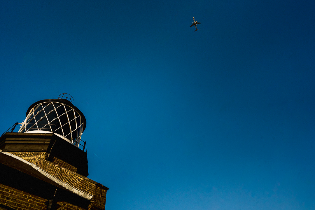 A plane flies through a clear blue sky in London above Trinity Buoy Wharf wedding venue