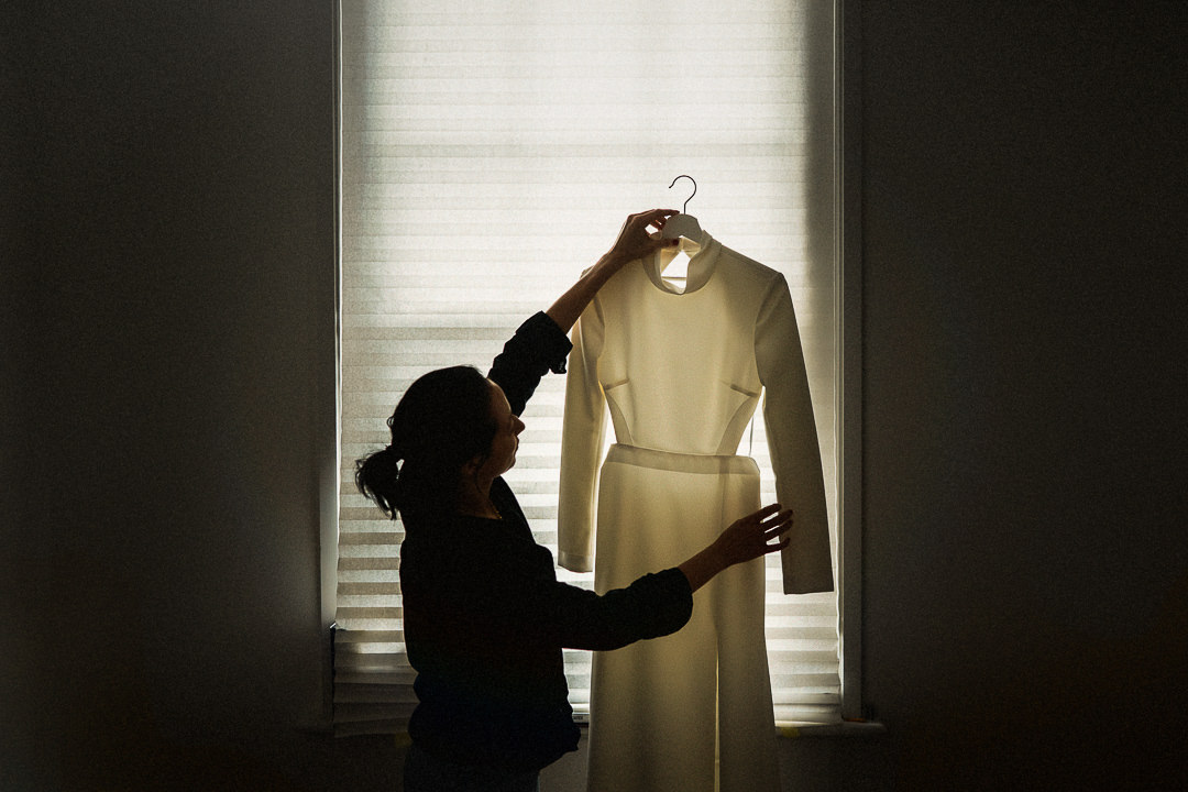 a documentary shot of a bride holding her dress ahead of her winter London wedding