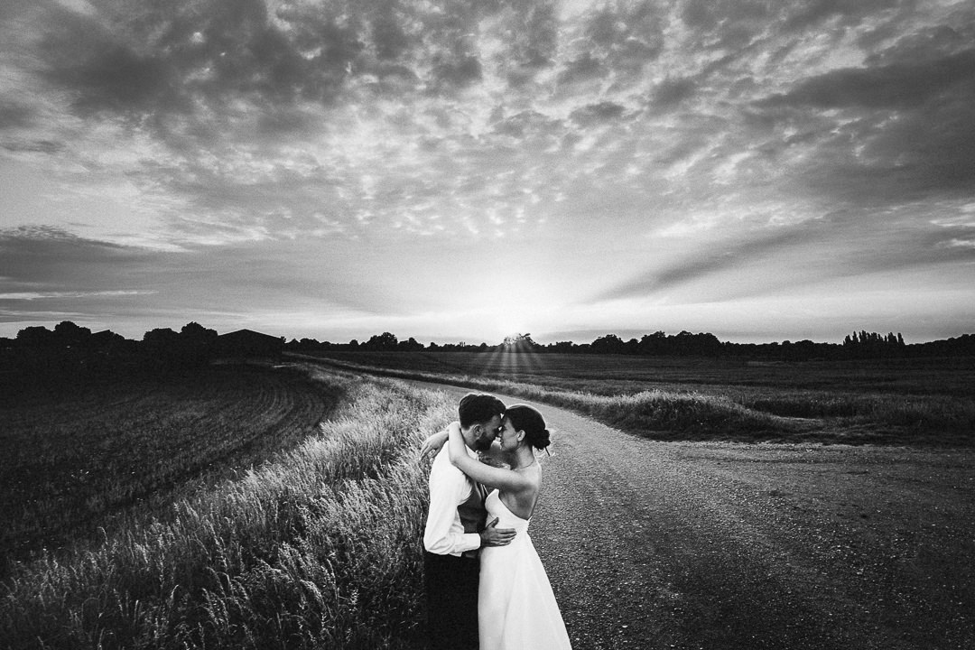 a couple embrace at sunset after their wedding at lodge farm barns in Essex