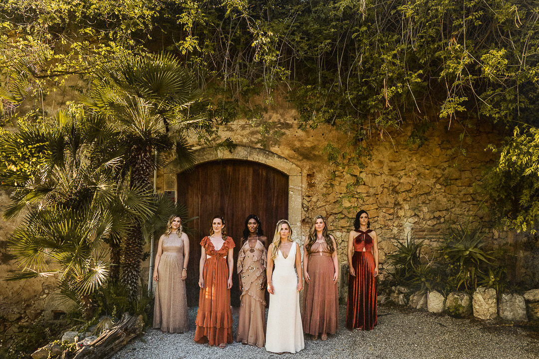 a bridal party pose for a fashion lead picture in the shade at cash Felix in Spain